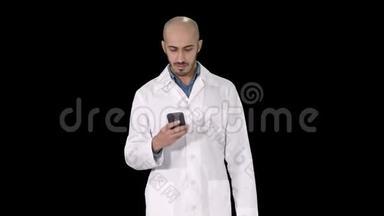 男阿拉伯医生走路时在电话上发短信，阿尔法频道